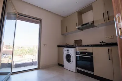 a kitchen with a washing machine and a window at Stylish Apartment Heart of Gueliz Netflix in Marrakech