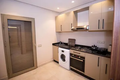 a kitchen with a stove and a washing machine at Stylish Apartment Heart of Gueliz Netflix in Marrakech