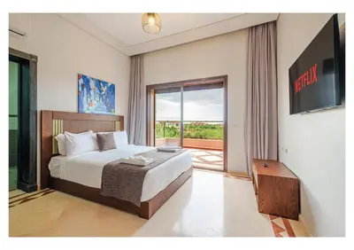 a bedroom with a bed and a sliding glass door at Villa Dahlia Jacuzzi, Stove, Pool in Marrakech