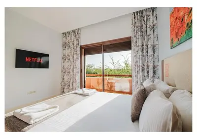 a bedroom with a large bed with a window at Villa Camelia avec Jacuzzi, Cuisinière, Piscine in Marrakech