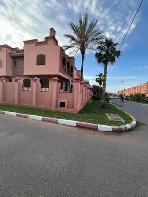 a pink house on the side of a street at Villa Ground Floor Rent Apt in Marrakech