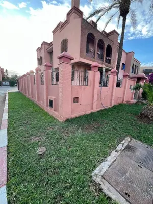 a pink building on the side of a street at Villa Ground Floor Rent Apt in Marrakech