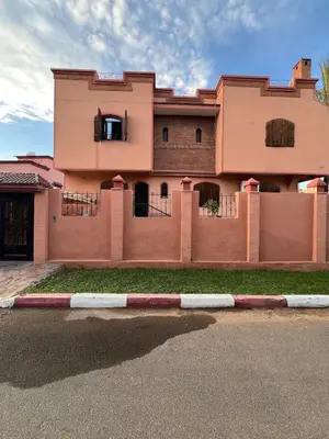 a pink building with a fence in front of it at Villa Ground Floor Rent Apt in Marrakech