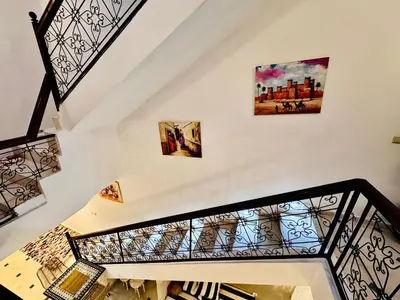 a staircase with three paintings on the wall at Riad Kimee Room 4 in Marrakech