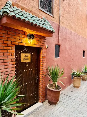 a brick building with a door with a sign on it at Riad Kimee Room 4 in Marrakech