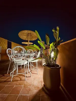 a patio with a table and chairs and an umbrella at Riad Kimee Room 4 in Marrakech