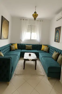a living room with a green couch and a table at Appartement Moderne & Climatisé in Marrakech