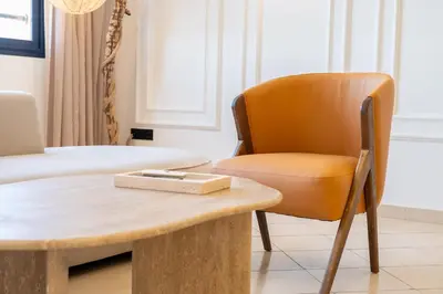 a living room with a table and a chair at Appartement élégant avec jacuzzi à deux pas de Guéliz in Marrakech