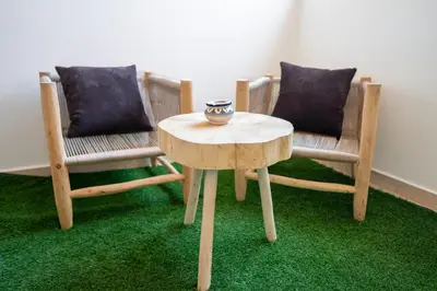 two chairs and a table and a table with a bowl on it at Appartement élégant avec jacuzzi à deux pas de Guéliz in Marrakech