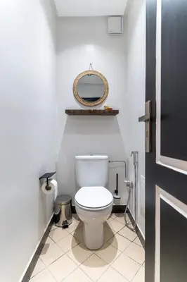 a bathroom with a white toilet and a mirror at Appartement élégant avec jacuzzi à deux pas de Guéliz in Marrakech