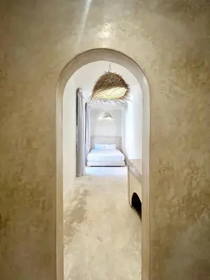 a bedroom with a bed in a white room at Riad Roseli in Marrakech