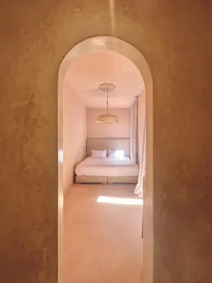 a hallway leading to a bedroom with a bed at Riad Roseli in Marrakech