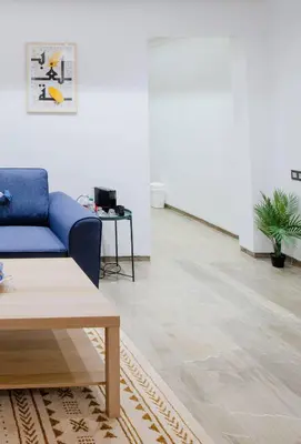a living room with a blue couch and a table at Gueliz Gem Chic, Comfy & Central in Marrakech