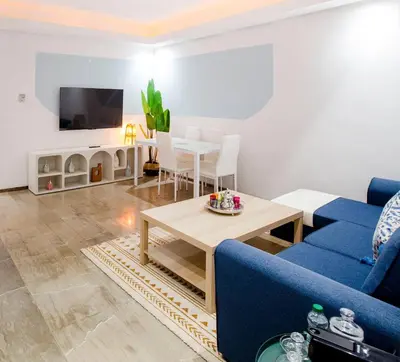 a living room with a blue couch and a table at Gueliz Gem Chic, Comfy & Central in Marrakech