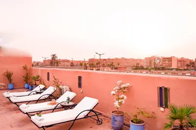 a row of white chairs sitting on top of a roof at Riad Mounir in Marrakech