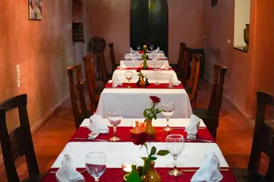 a dining room with white tables with red napkins at Riad Mounir in Marrakech