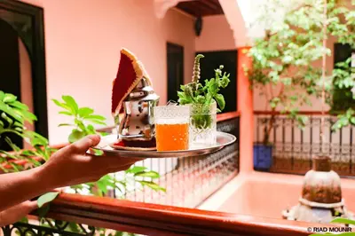 a person holding a plate of food on a balcony at Riad Mounir in Marrakech