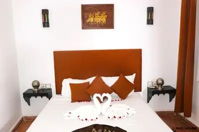 a bedroom with a bed with two swans on it at Riad Mounir in Marrakech