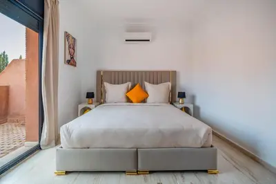 a bedroom with a large bed with orange pillows at Villa Palmera - 6 people - Pool - Marrakech in Marrakech