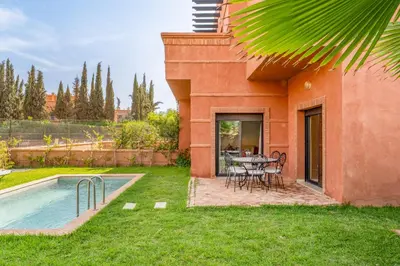 a patio with a table and chairs next to a house at Villa Palmera - 6 people - Pool - Marrakech in Marrakech