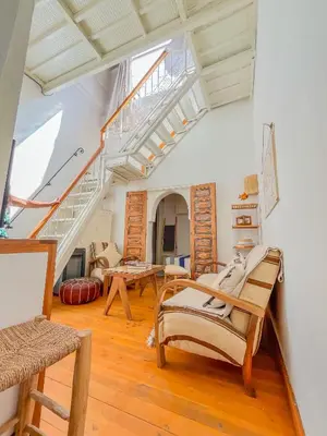 a living room with wooden floors and stairs at Ma petite maison cosy en medina in Marrakech