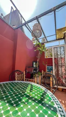 a room with a table and chairs and a window at Ma petite maison cosy en medina in Marrakech
