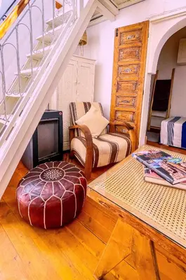 a living room with a staircase and a chair and a couch at Ma petite maison cosy en medina in Marrakech