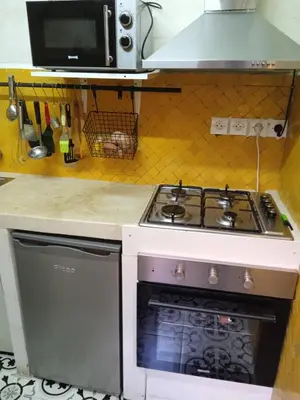 a kitchen with a stove and a microwave at Ma petite maison cosy en medina in Marrakech