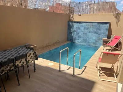 a small swimming pool with a table and chairs in it at Villa Marrakech in Marrakech