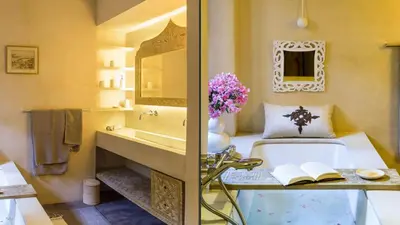 a bathroom with a tub and a sink and a mirror at Dar-el-adaka in Marrakech