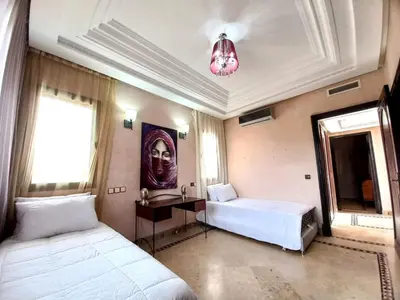 a bedroom with two beds and a desk and a mirror at CYCAS VILLA TARGA GARDEN -Only Family in Marrakech