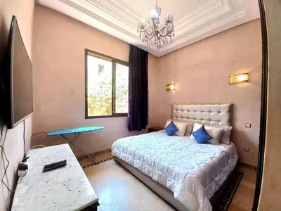a bedroom with a bed and a chandelier at CYCAS VILLA TARGA GARDEN -Only Family in Marrakech