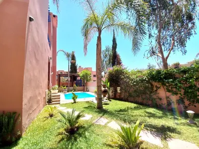 a backyard with a swimming pool and palm trees at CYCAS VILLA TARGA GARDEN -Only Family in Marrakech