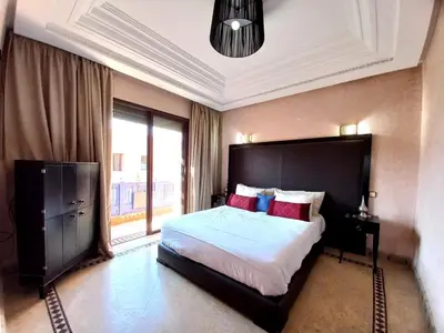 a bedroom with a large bed and a large window at CYCAS VILLA TARGA GARDEN -Only Family in Marrakech
