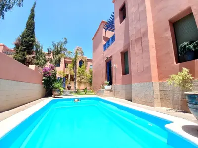 a swimming pool in the backyard of a house at CYCAS VILLA TARGA GARDEN -Only Family in Marrakech