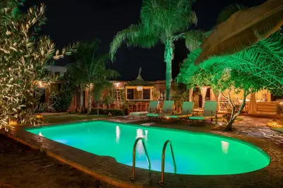 a swimming pool in front of a house at night at Villa Sidi Oasis in Marrakech