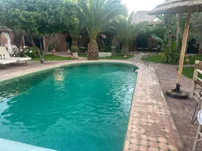 a swimming pool with blue water in a yard at Villa Sidi Oasis in Marrakech