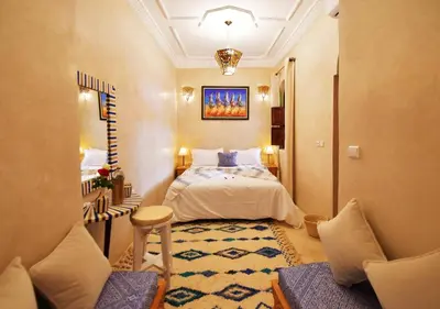 a hotel room with a bed and a table and chairs at RIAD Zina Rose 89 in Marrakech