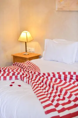 a bed with a red and white blanket on it at RIAD Zina Rose 89 in Marrakech