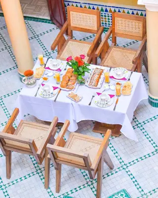 a white table with food on it with chairs at RIAD Zina Rose 89 in Marrakech