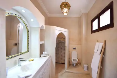 a bathroom with a sink and a toilet and a mirror at RIAD Zina Rose 89 in Marrakech