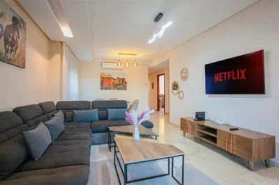 a living room with a couch and a tv at The Garden Course - Marrakech - Prestigia in Marrakech