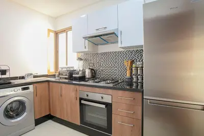 a kitchen with a stainless steel refrigerator and a dishwasher at The Garden Course - Marrakech - Prestigia in Marrakech