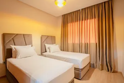 a hotel room with two beds and a window at The Garden Course - Marrakech - Prestigia in Marrakech