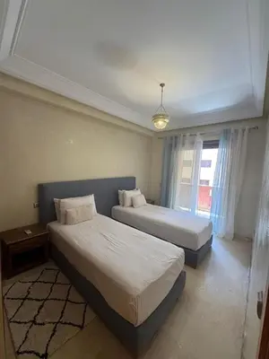 a bedroom with two beds and a window at Sofia Palmeraie Appartement in Marrakech