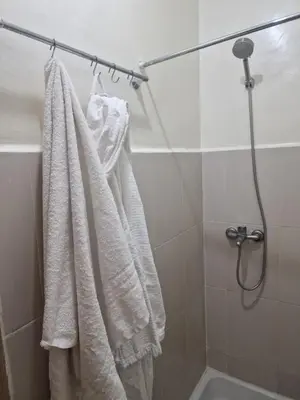 a bathroom with white towels hanging on a shower at appartement mabrouka in Marrakech
