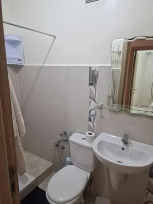 a bathroom with a white toilet and a sink at appartement mabrouka in Marrakech