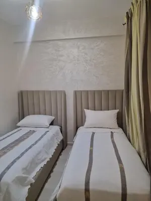 two beds sitting next to each other in a bedroom at appartement mabrouka in Marrakech
