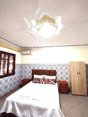 a bedroom with a white bed and a chandelier at Maison traditionnelle marocaine à Marrakech in Marrakech