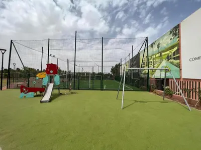 a tennis court with a net and a playground at Noria Golf Marrakech in Marrakech